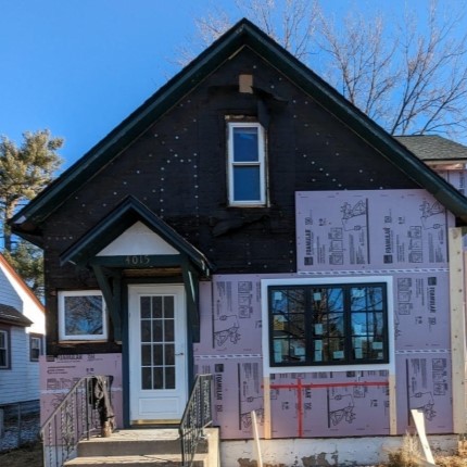 house undergoing exterior insulation application during re-siding project