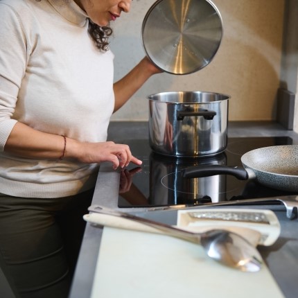 woman cooking on induction stovetop