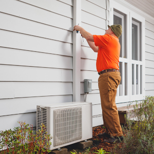 Worker examining a variable capacity heat pump