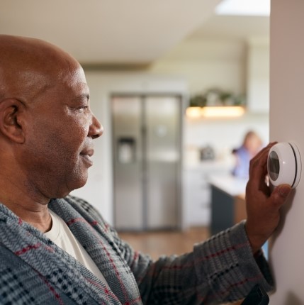 man adjusting thermostat