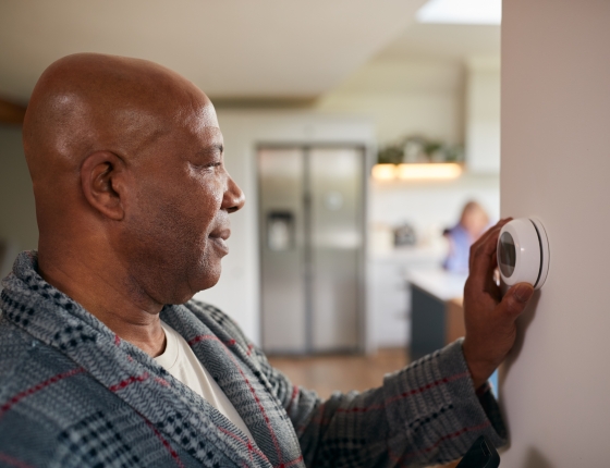 man adjusting thermostat