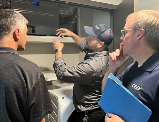 CEE staff explaining energy recovery ventilator in apartment unit