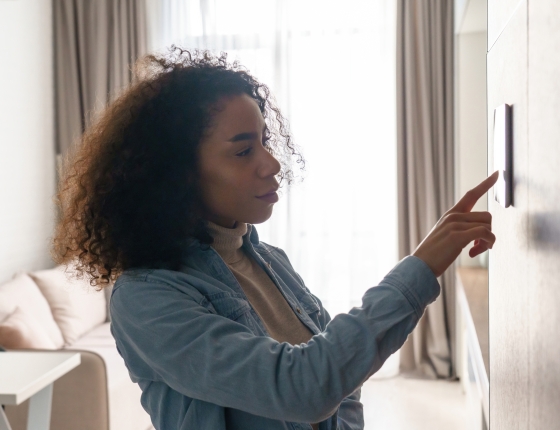 woman adjusting thermostat