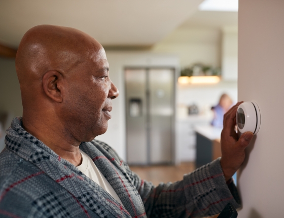 man adjusting smart thermostat