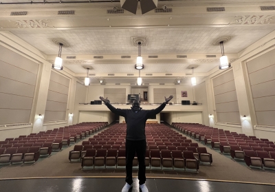 man in front of lit up auditorium
