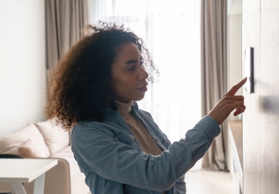 woman adjusting thermostat