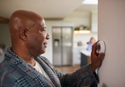man adjusting smart thermostat