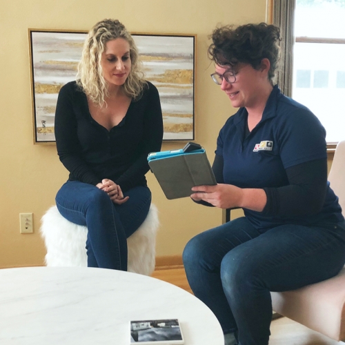 two women talking looking at an Ipad