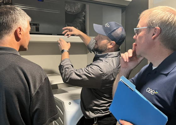 CEE staff explaining energy recovery ventilator in apartment unit