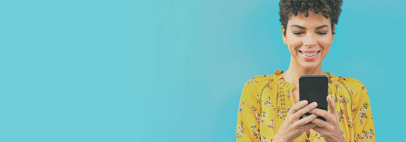 A woman looks at her phone and smiles