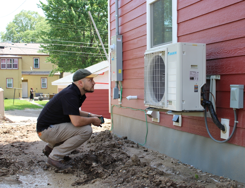 A person looks at a heat pump.