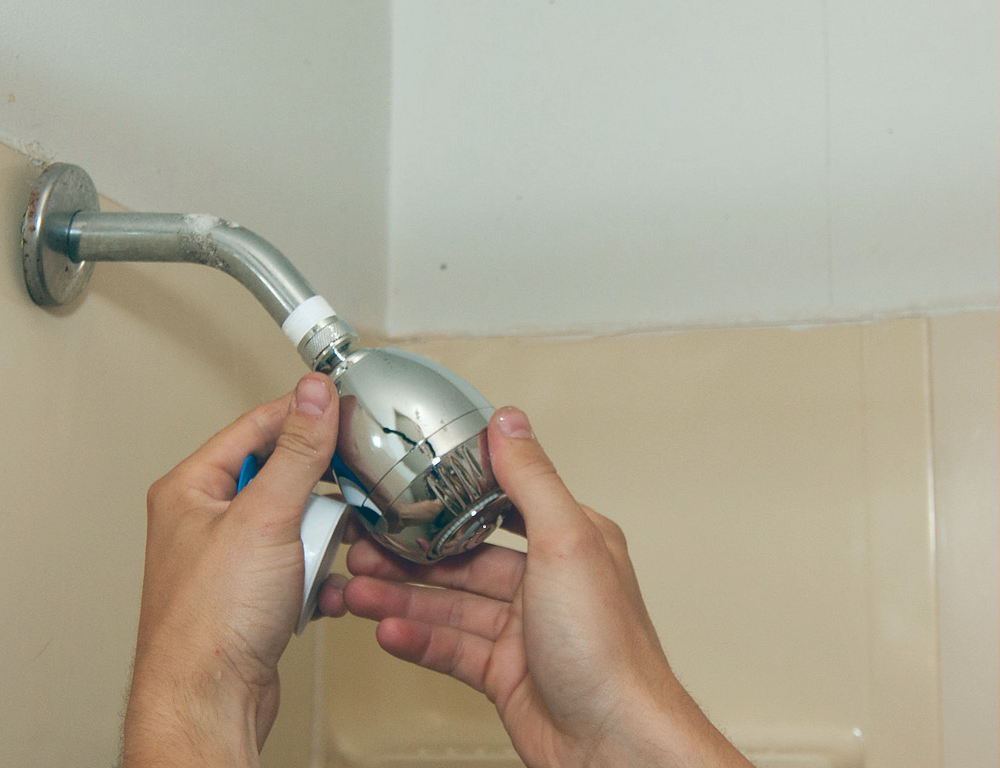 hand screwing in showerhead