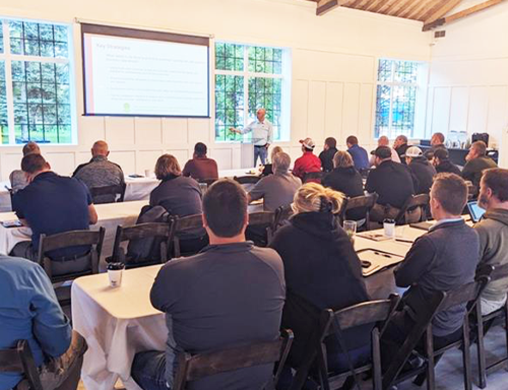 training classroom with individuals listening to a speaker