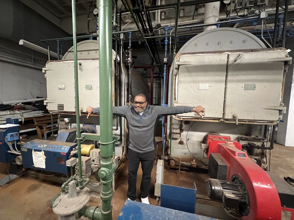 man in front of two boilers