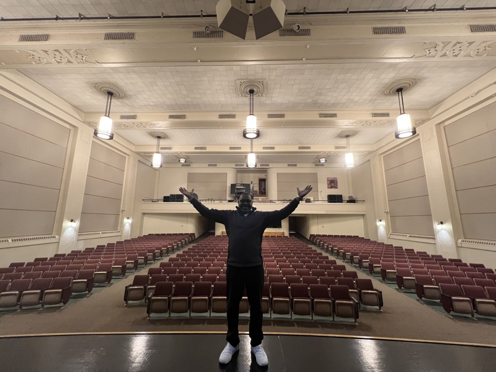 man in front of lit auditorium