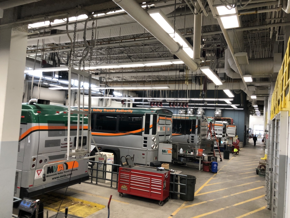 Garage with busses and overhead LED lighting