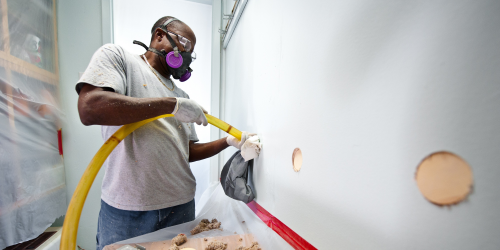 man installing wall insulation