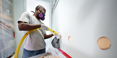 man installing wall insulation