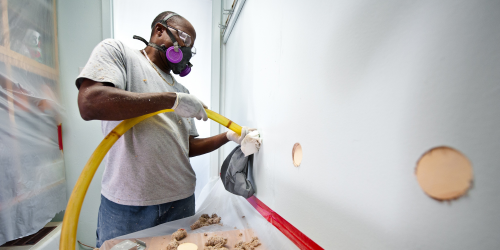 man installing wall insulation