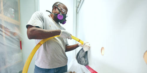 man installing wall insulation