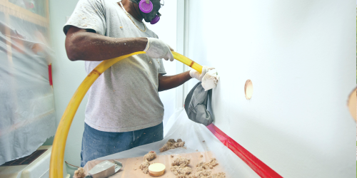 man installing wall insulation