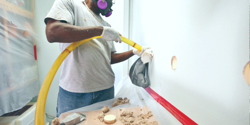 Man installing wall insulation