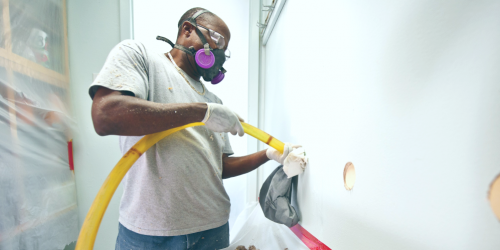 man installing wall insulation