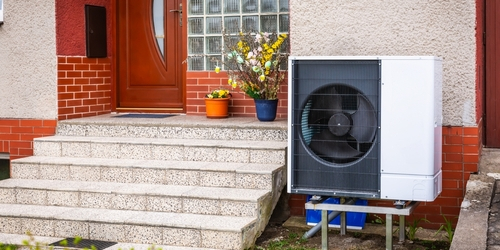 Air source heat pump on side of house