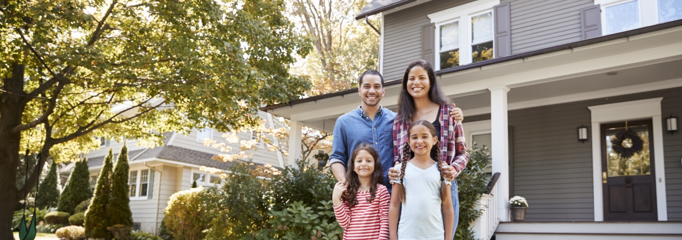 family standing in front of a house