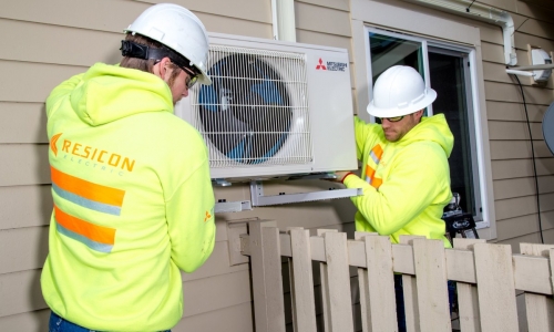 workers installing an air source heat pump