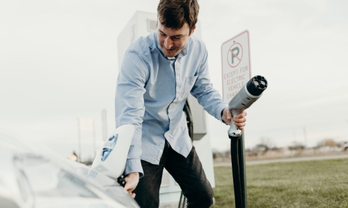 man charging electric car