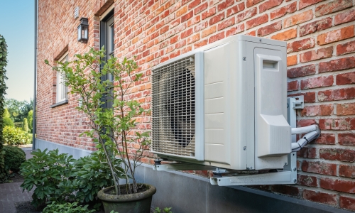 air source heat pump outside next to plant