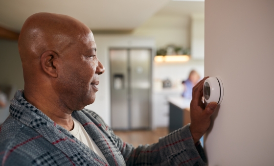 man adjusting thermostat