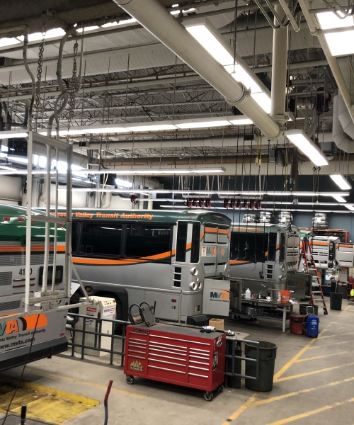 Garage with busses and overhead LED lighting