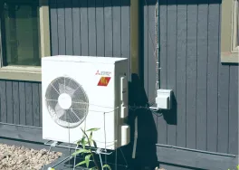 air source heat pump outside next to plant